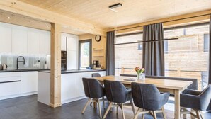 A modern kitchen with white cabinets, a black faucet, and a wooden ceiling. - #6b mit Sauna & Pool by Interhome (Sankt Georgen am Kreischberg)