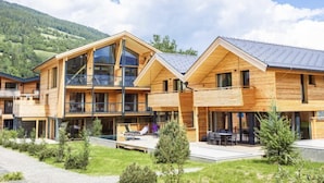 Un edificio moderno de madera con ventanas amplias y un espacio exterior techado.