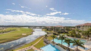 Ein Golfplatz mit Fluss, Schwimmbad und Hotelgebäuden.