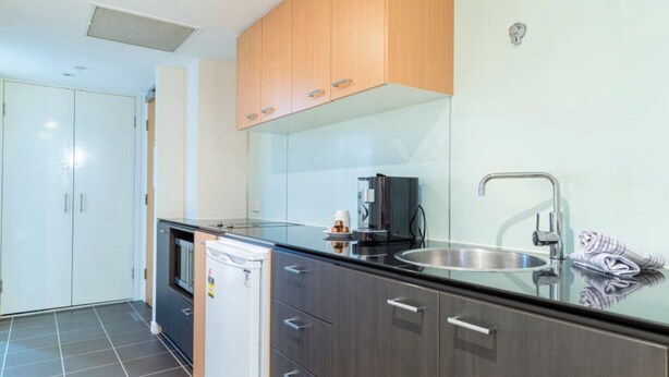 A modern kitchen with a stainless steel sink, a coffee machine, and a dishwasher.