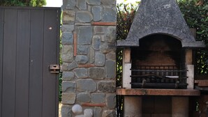 A stone-built outdoor oven with a chimney, a wooden door, and a metal gate. - Villa 'Bella Toscana Relax' with Mountain View, Wi-Fi, and Air Conditioning (Monsummano Terme)