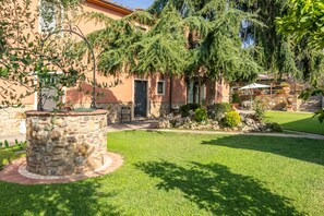 A stone fountain, a well-maintained lawn, and a building with a stone facade and windows. - Villa 'Bella Toscana Relax' with Mountain View, Wi-Fi and Air Conditioning (Monsummano Terme)