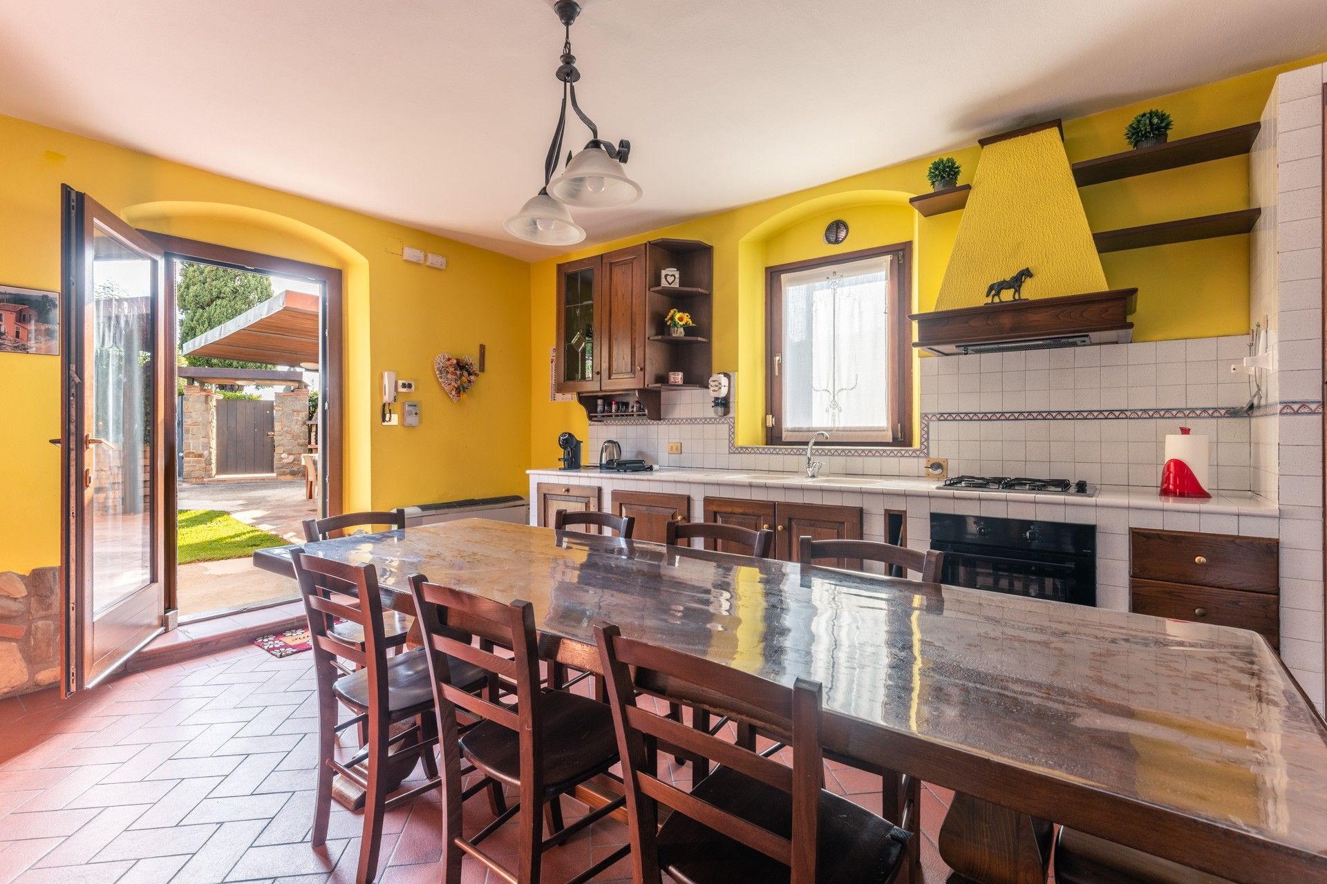 Una cocina con una isla grande, armarios de madera y una pared de acento amarilla.