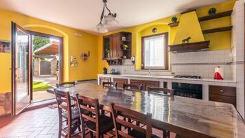 Una cocina con una isla grande, armarios de madera y una pared de acento amarilla.