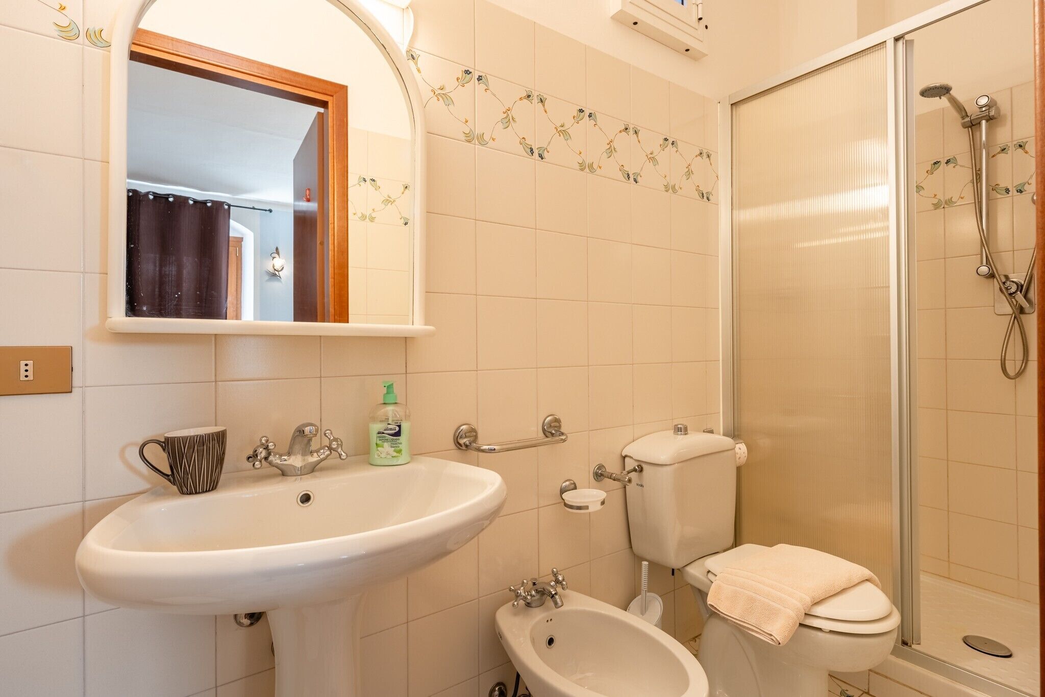 Ein Badezimmer mit Waschbecken, Bidet, Toilette und Dusche.
