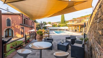 Una zona patio all'aperto con piscina, posti a sedere esterni e vista sugli edifici circostanti.