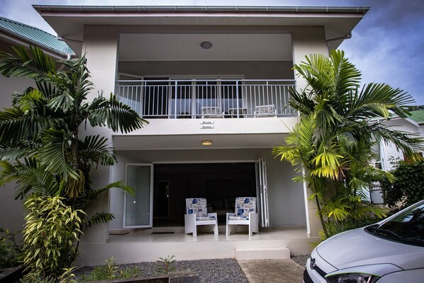 Guests can enjoy a balcony with a view of lush surroundings from this two-story residence.