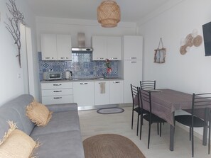 A modern kitchen with white cabinets, a built-in oven, and a blue-tiled backsplash.