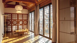 A traditional Japanese room with tatami flooring, a low wooden table, and sliding doors with geometric patterns.