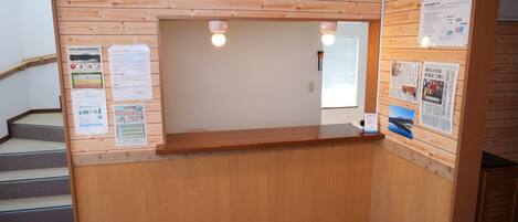 Un mostrador de recepción con paneles de madera y un cartel encima.
