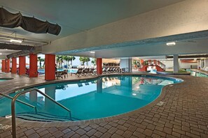 Relax by the pool surrounded by lounge chairs and a staircase leading to an upper level.