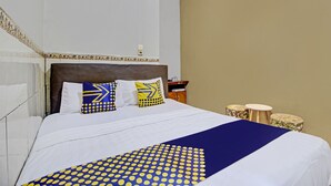 A hotel room with a large bed, a headboard, and a bedside table with a lamp. - Hotel O Bagus Jaya Hotel (Ambarawa)