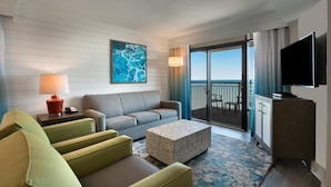 A hotel room with a sofa, armchairs, a TV, a lamp, and a view of the ocean. - Charming OceanView  3BR  Condo 6th Floor (Myrtle Beach)