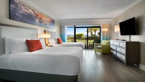 Une chambre d’hôtel avec deux lits, une télévision, une commode et un balcon avec vue.