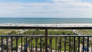 A beach view from a balcony with a railing, palm trees, and a clear sky. - Oceanfront Room: Your Retreat Awaits 4th Floor (Myrtle Beach)