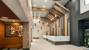 Una zona de recepción moderna con pared de ladrillo, un mostrador y un banco de madera.