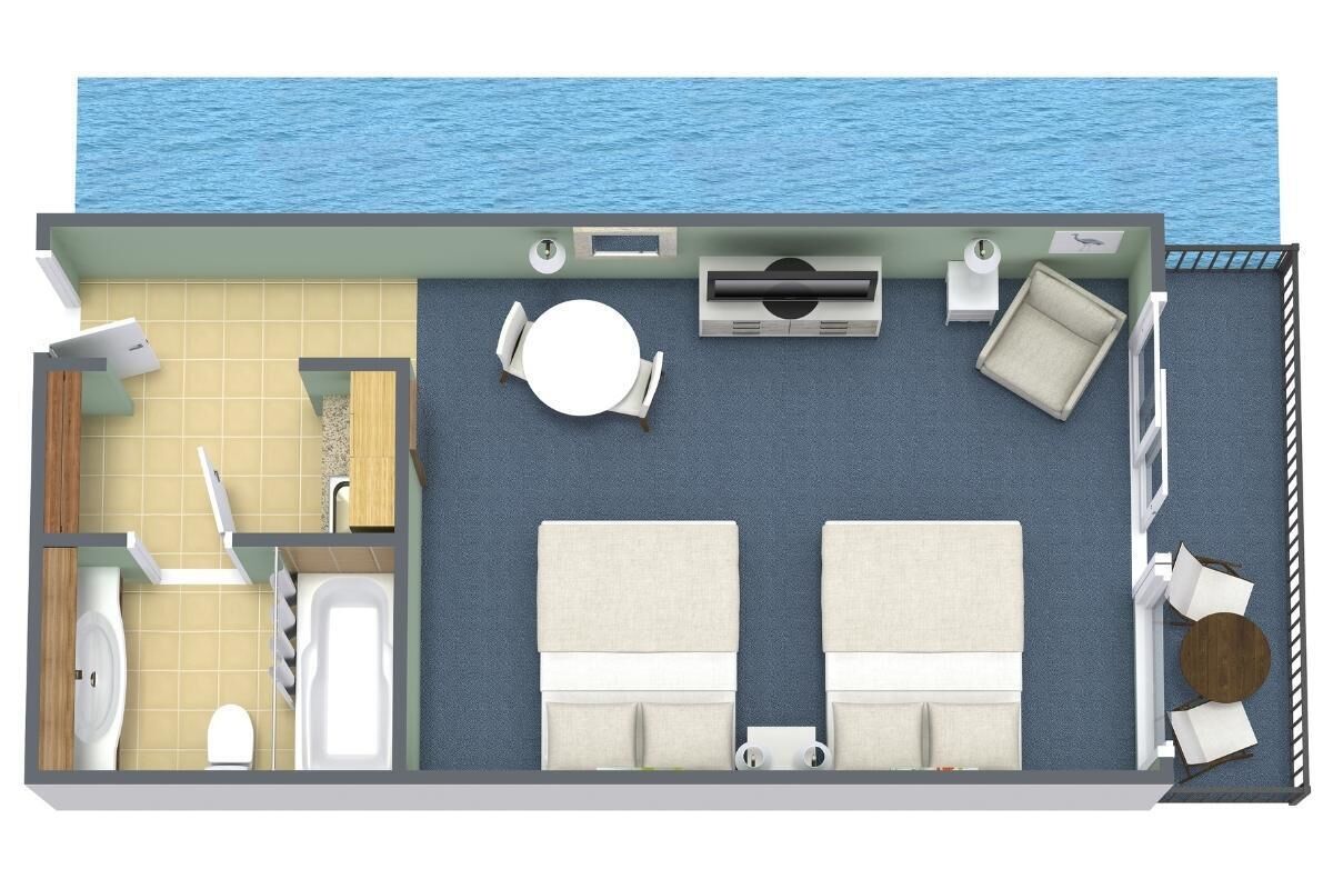A room with a bed, a small table, a chair, a toilet, and a sink.