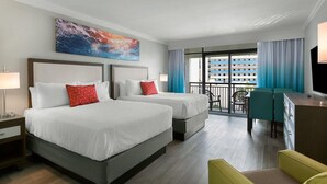 A hotel room with two beds, a desk, a chair, a TV, and a balcony with a view of a building. - Tranquil Ambiance: South Ocean View Room 3rd Flr (Myrtle Beach)