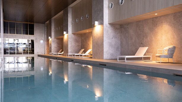 A swimming pool with lounge chairs and a view of the city. - The Ritz + Parking & Amenities (Melbourne)