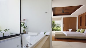 Un baño moderno con una bañera grande, un espejo y una planta en maceta.