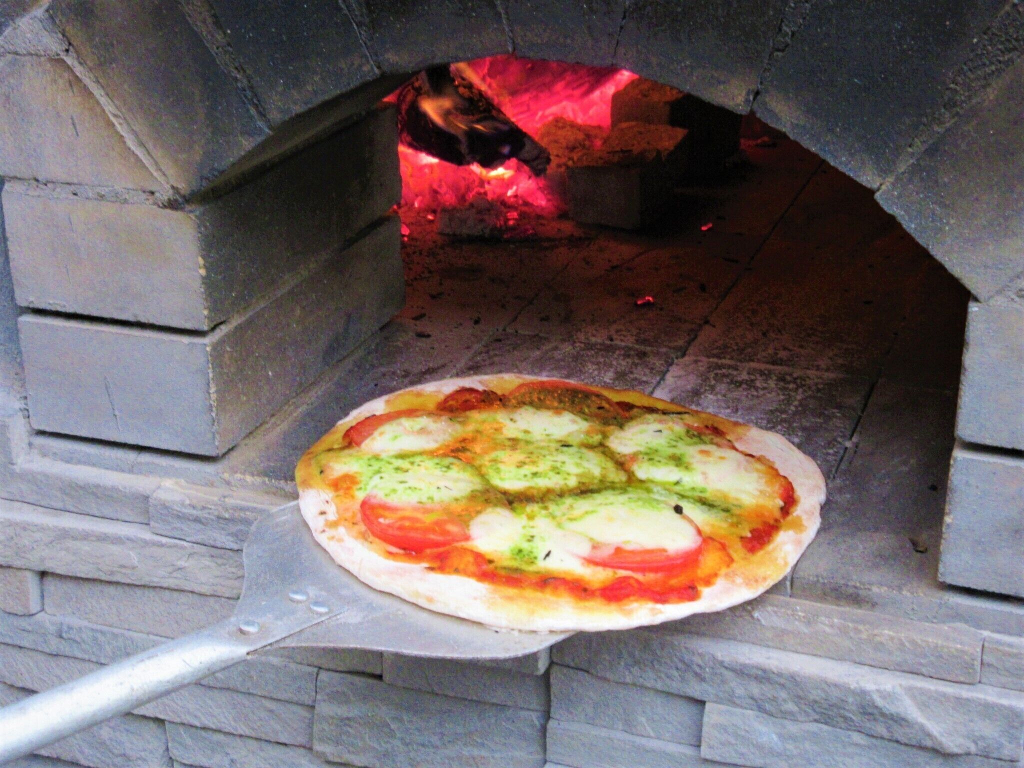 A pizza being baked in a stone oven.