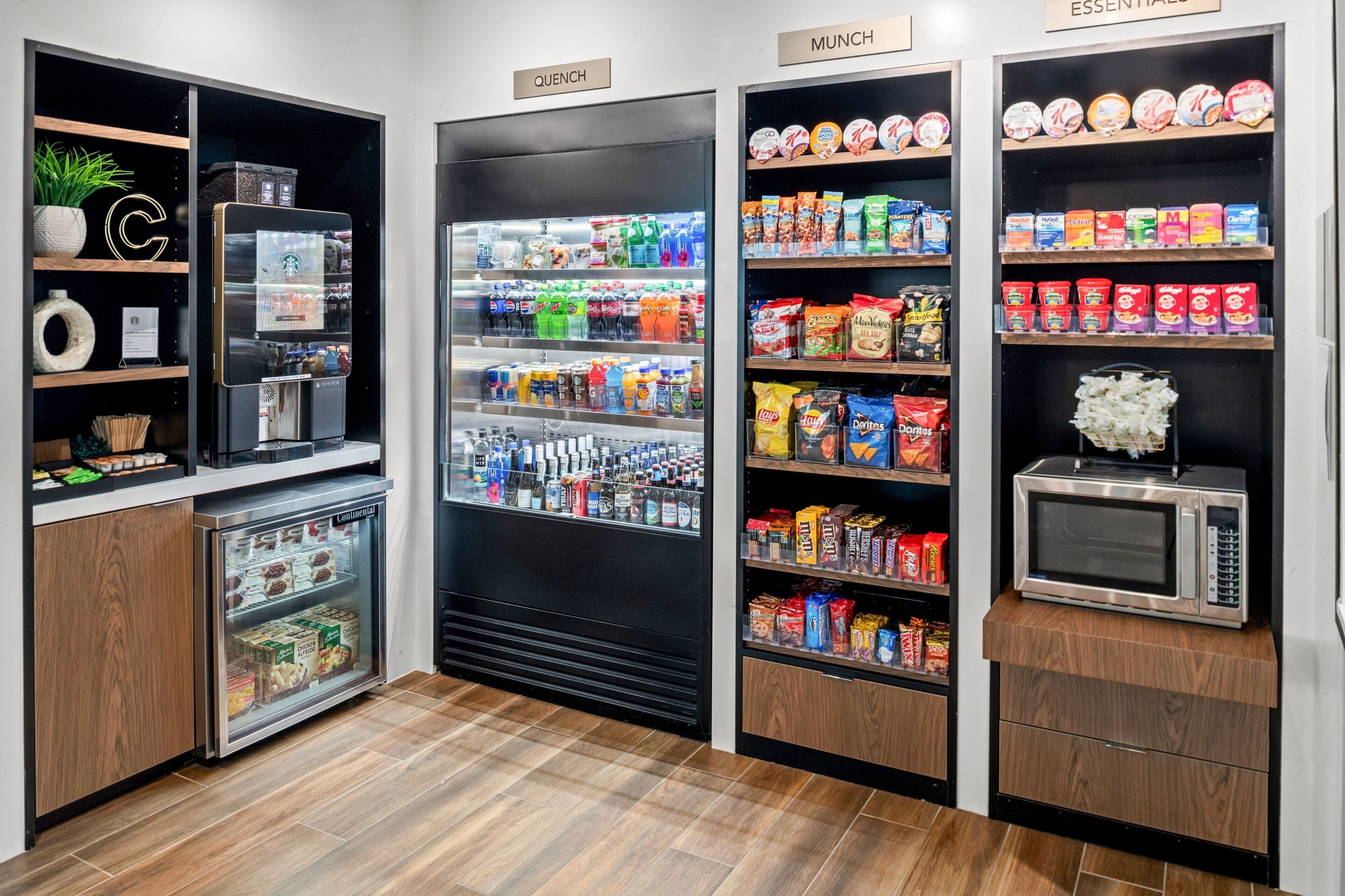 A self-service food area with refrigerated sections, snack shelves, and a microwave.