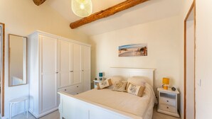 Una camera da letto con un letto, comodini, un armadio e un quadro appeso al muro.