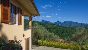 Une maison dotée d’un balcon donnant sur un paysage montagneux.