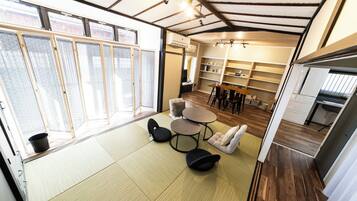 Cozy living space with a dining area, kitchenette, and large windows.