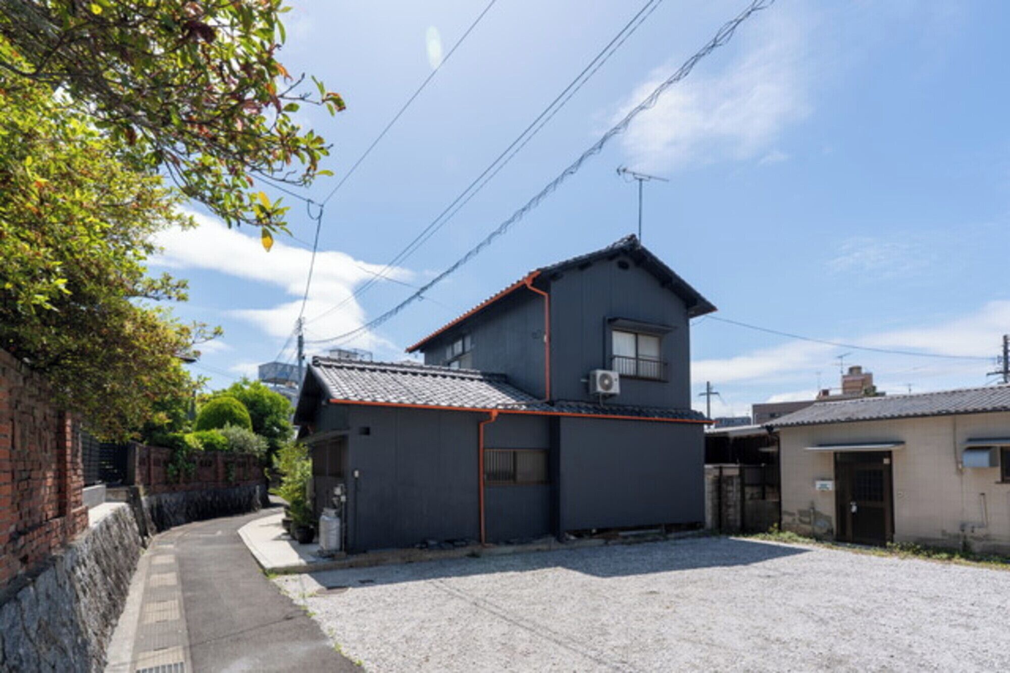 A residential building with a sloped roof, a small attached garage, and a paved driveway.