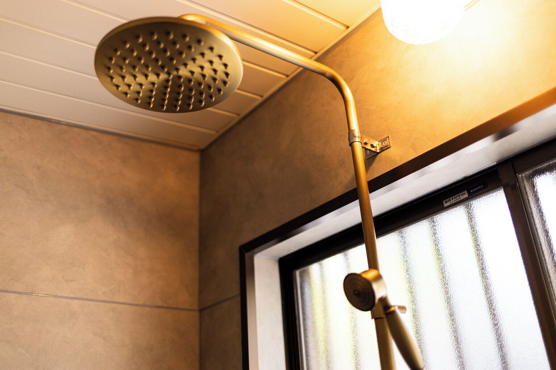 A showerhead with a curved handle and a metallic finish.