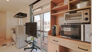 A modern kitchen with a built-in oven, microwave, and a large window.