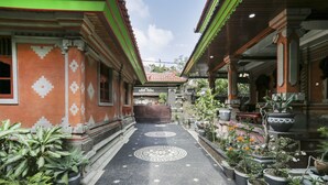 Une cour traditionnelle agrémentée de plantes en pot et d’un chemin décoratif.