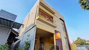 A two-story building with a balcony on the upper floor, a visible entrance, and a sign indicating a business or service. - Hotel O Umi Rahayu Guesthouse (Semarang)