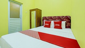 A hotel room with a bed, a wardrobe, and a door. - Hotel O Umi Rahayu Guesthouse (Semarang)