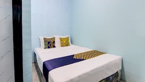A bedroom with a bed, pillows, and a blanket. - Hotel O Gioba Kost Syariah (Wirosari)