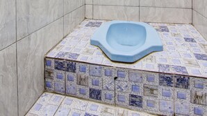 A bathroom with a blue freestanding bathtub, tiled walls, and a mosaic floor. - Hotel O Gioba Kost Syariah (Wirosari)