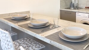 Een keuken met een marmeren aanrecht, drie kommen, een spoelbak en een vaatwasser.