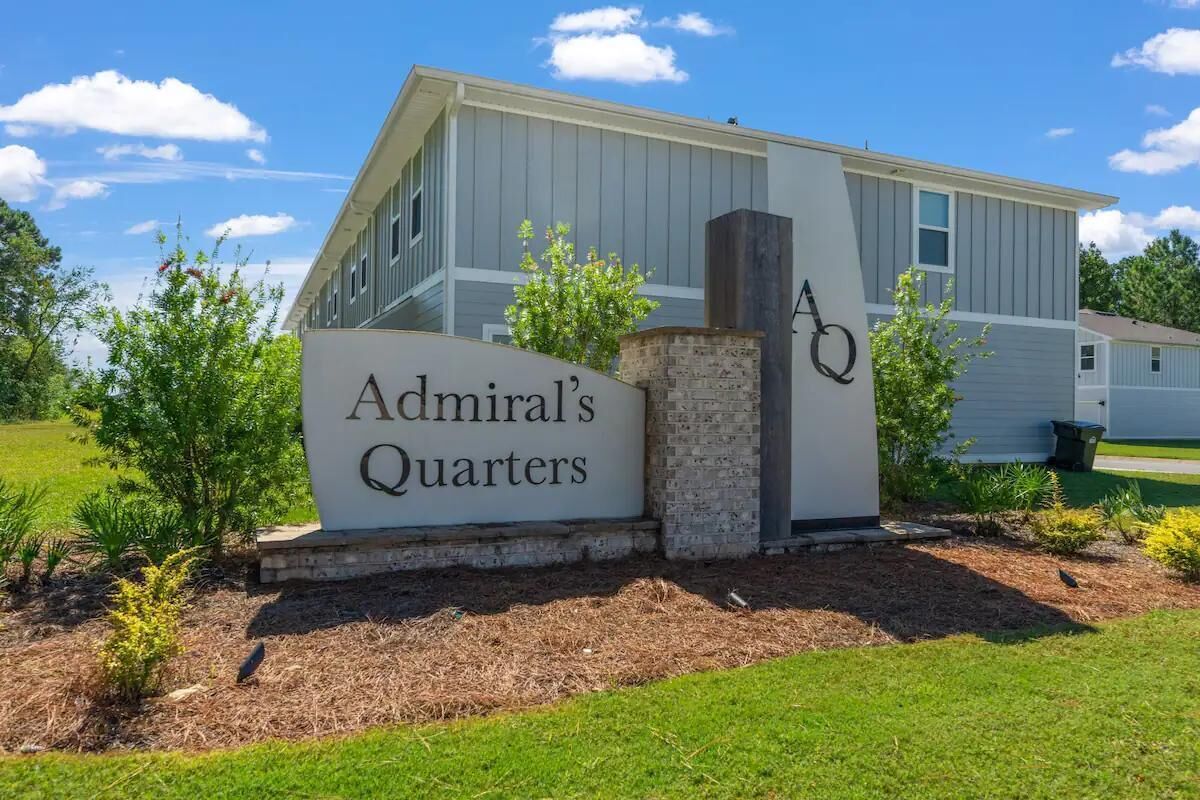 A building with a sign reading 'Admiral's Quarters' and a stone pillar.