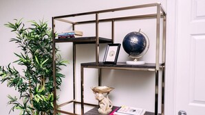 Une pièce comprenant une étagère en métal où sont rangés des livres, un globe terrestre et un objet décoratif.