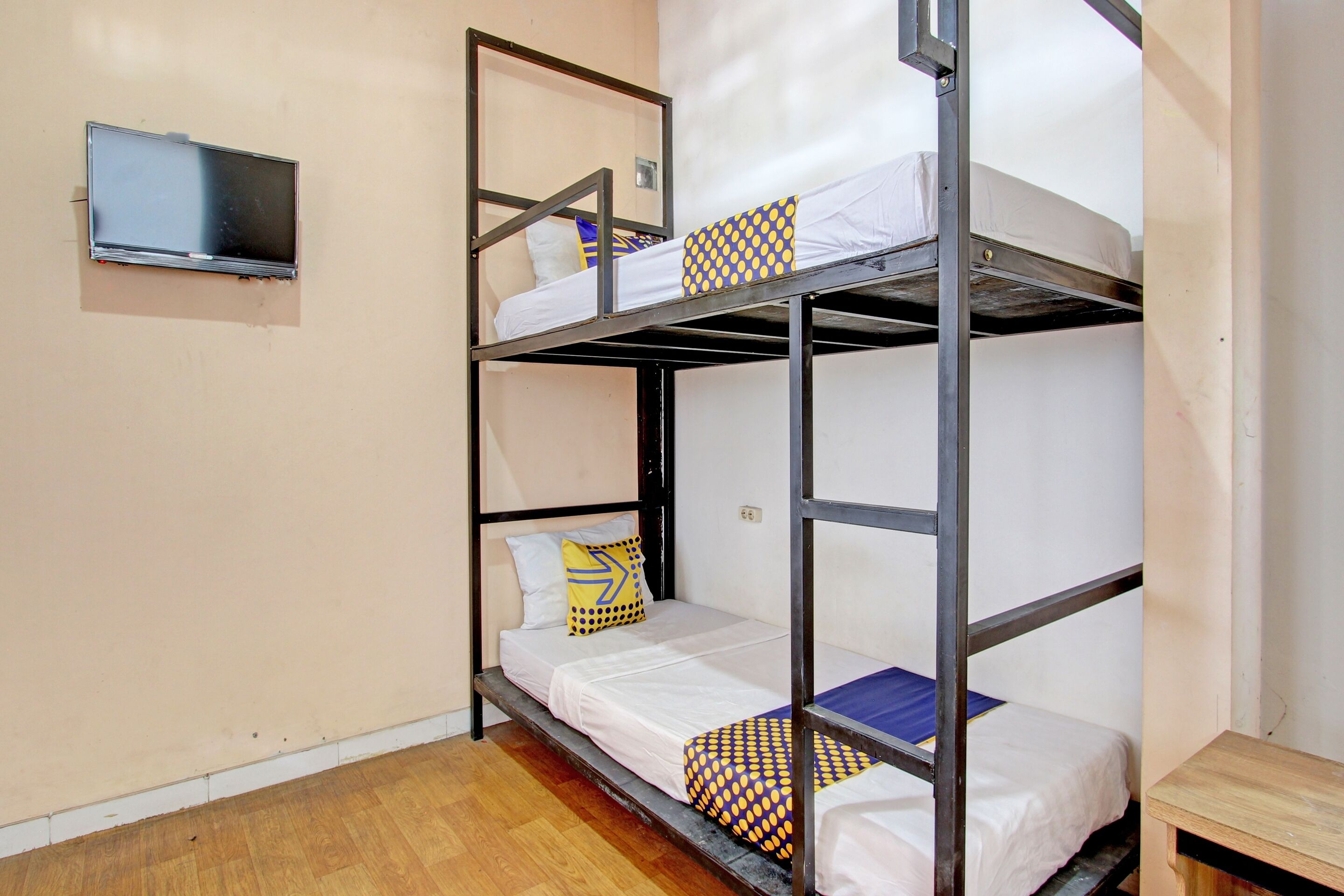 A bunk bed room with a television mounted on the wall.