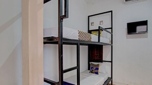 Une chambre avec des lits superposés et un téléviseur fixé au mur.