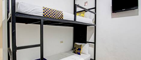 A bunk bed room with a TV mounted on the wall.