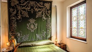 A room with a bed, a window with stained glass, and a lamp on a bedside table. - Dimora Del Filosofo (Verona)