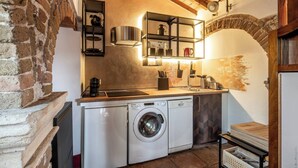 A compact kitchen with a washing machine, a sink, and a stove. - Dimora Del Filosofo (Verona)