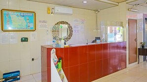 A reception area with a red counter, a map on the wall, and various informational signs. - Hotel O Sion Holiday (South Tangerang)