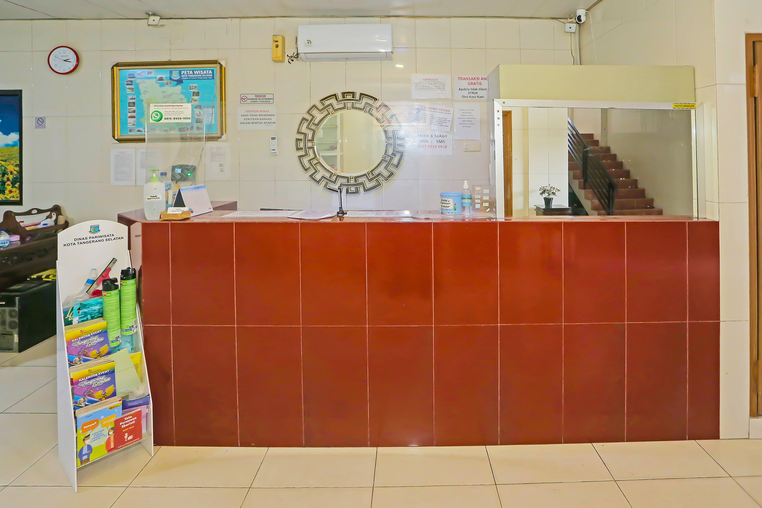A reception desk with a mirror, a map, and a sign indicating a 24-hour service area.