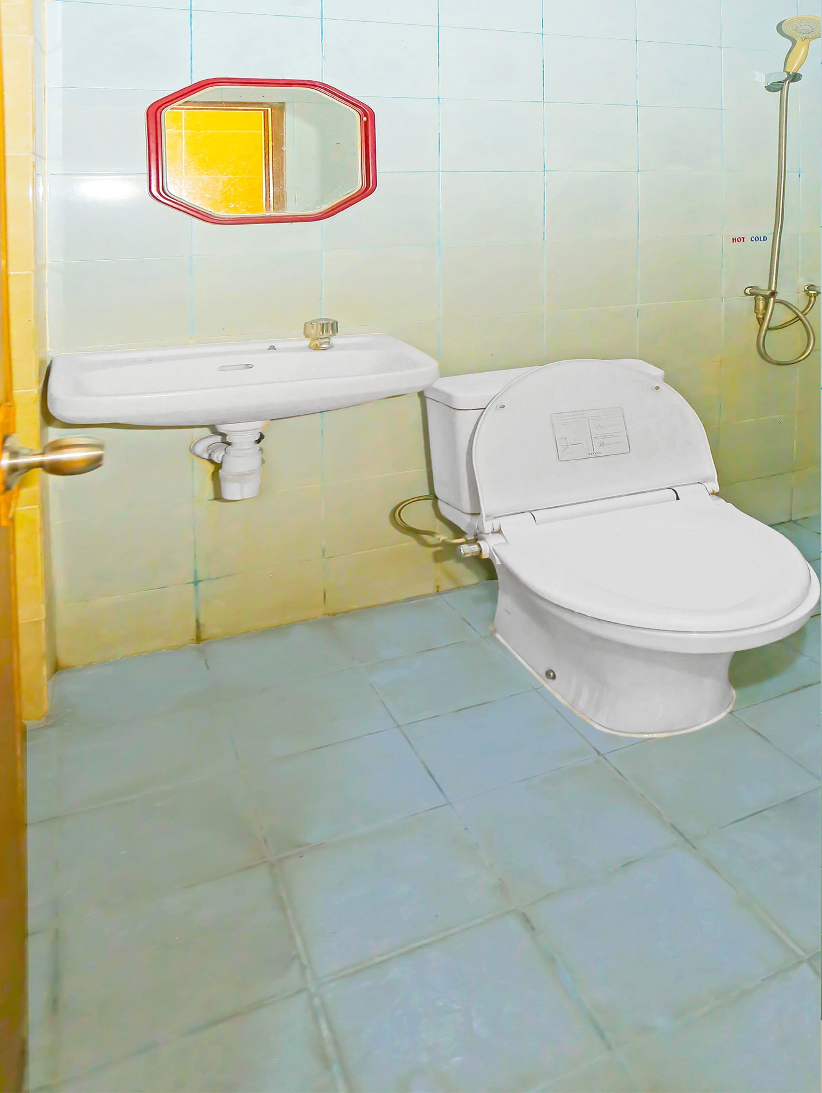 A bathroom with a toilet, sink, and a shower.