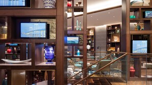 A modern interior with a staircase, wooden flooring, and various decorative items on shelves. - Andaz Macau  (Cotai)
