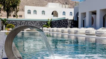 Una piscina al aire libre de temporada, sombrillas